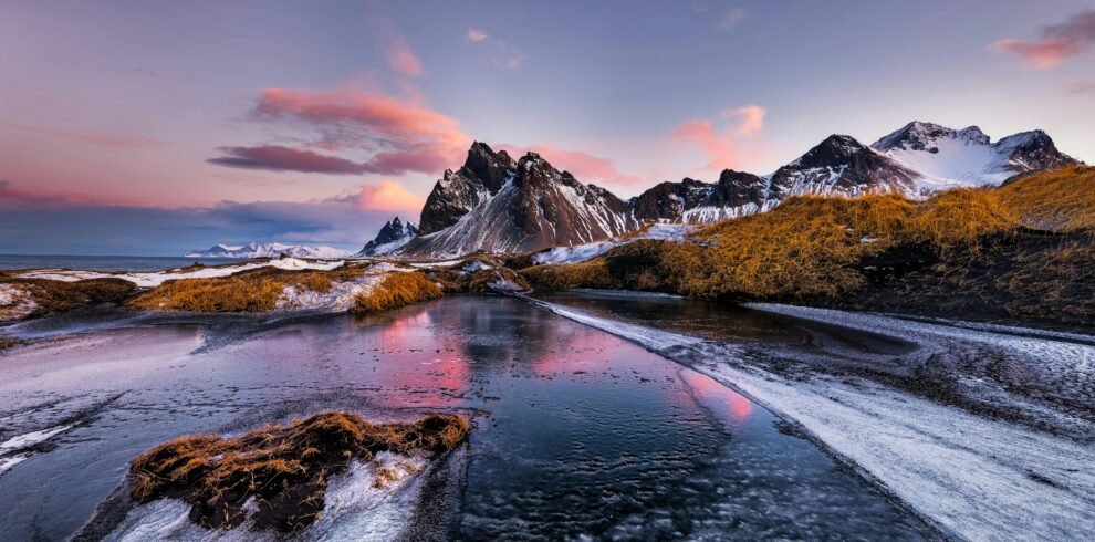Vestrahorn mountains with frozen lake at sunset, stunning natural landscape.