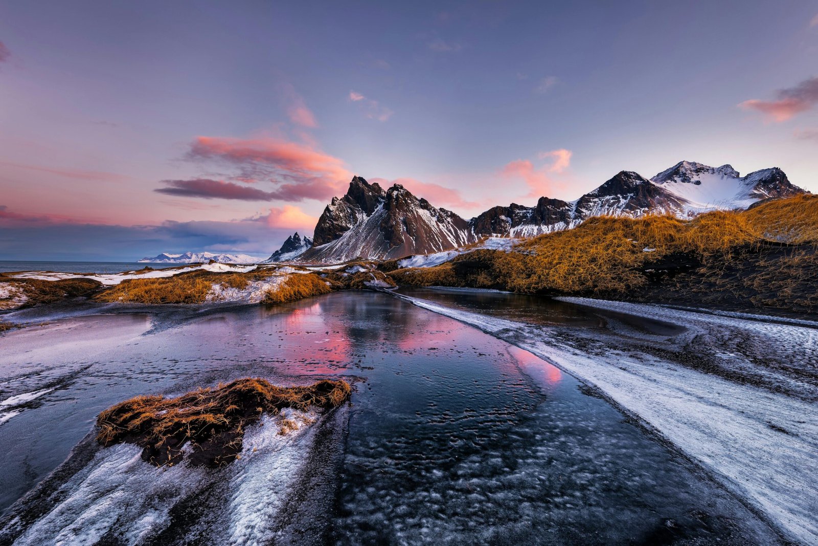 Vestrahorn mountains with frozen lake at sunset, stunning natural landscape.